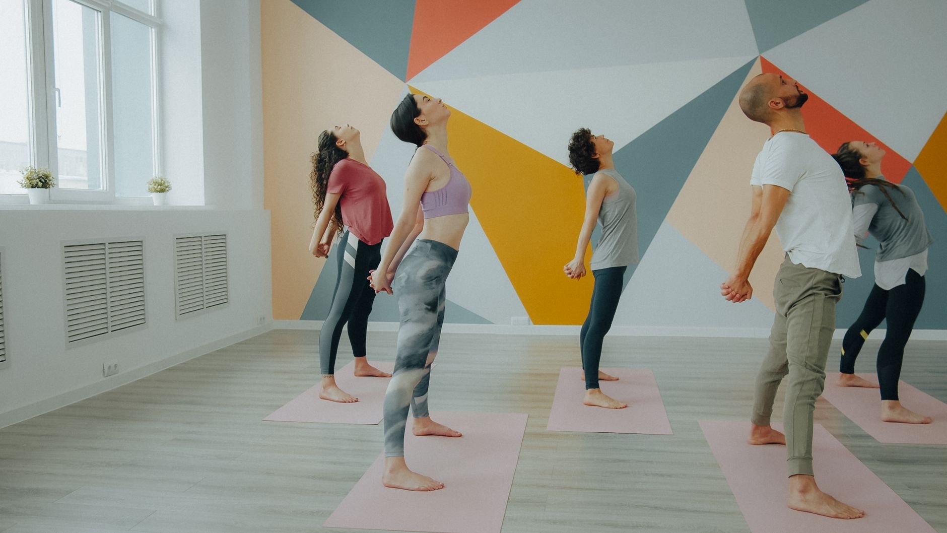 A group practicing yoga together in a bright community studio